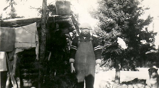 Ed Theriau in front of his trapping cabin