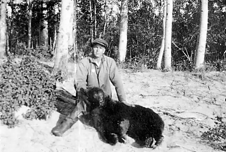 August Sunstadt with a black bear he trapped.