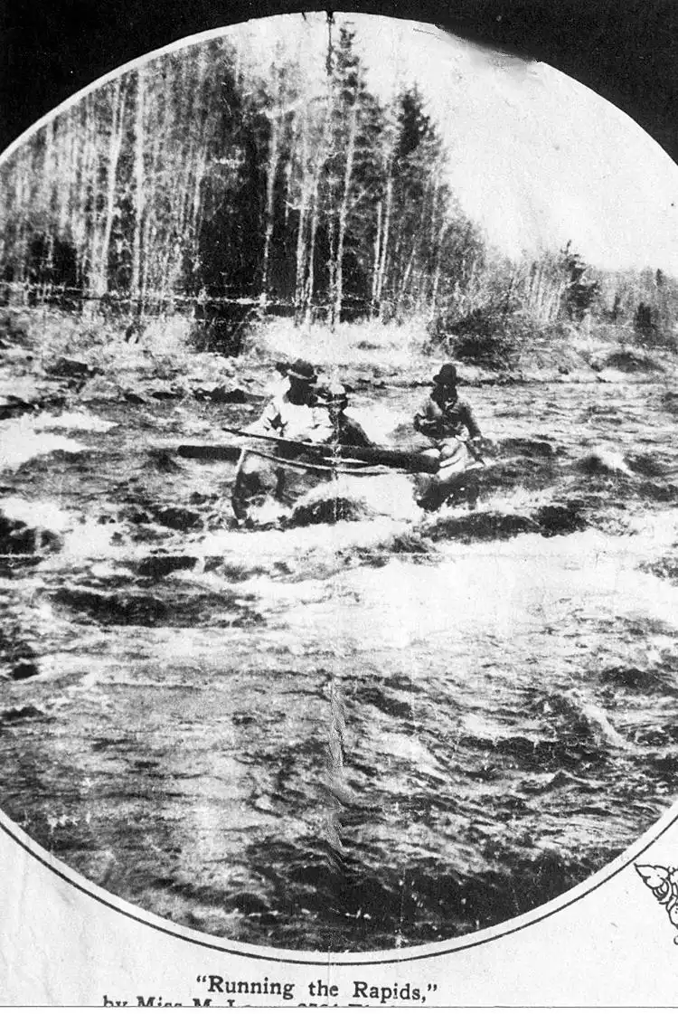 Indians running the rapids in a canoe.