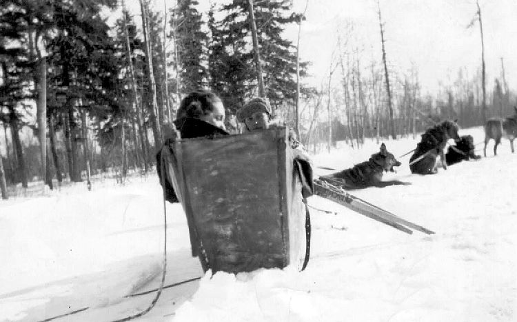 Kay & Ronnie sit in Leland’s dog sled.